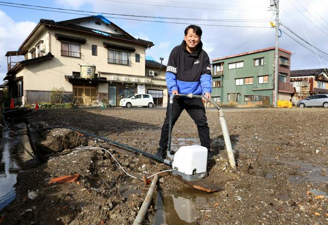 公費解体が終わり、源泉だけが残った宝湯の本館跡に立つ橋元宗太郎さん=2024年12月12日、石川県珠洲市、林敏行撮影