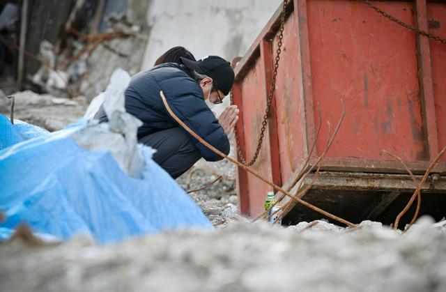 店舗跡で線香を手向け、妻の由香利さんと長女の珠蘭さんを追悼する楠健二さん=2025年1月1日午後2時13分、石川県輪島市河井町、伊藤進之介撮影