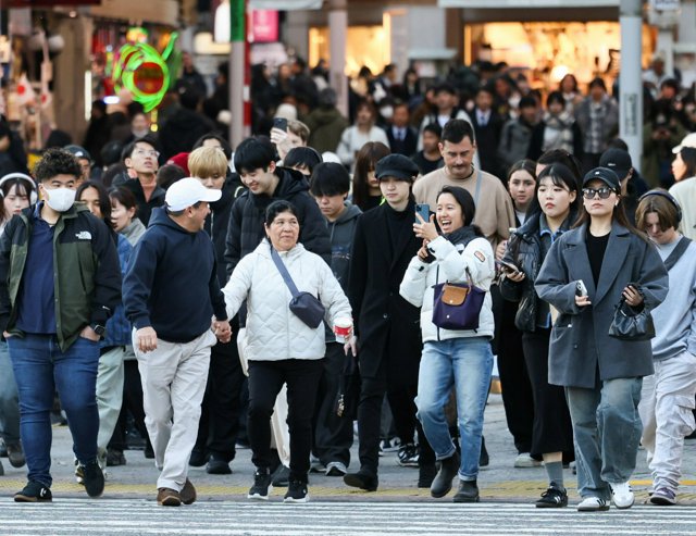 スクランブル交差点を渡る外国人観光客ら=2024年12月18日午後3時、東京都渋谷区、友永翔大撮影