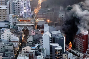 煙を上げて燃える建物（右下）。左上は通天閣=2025年1月21日午後5時18分、大阪市浪速区、朝日新聞社ヘリから、小杉豊和撮影