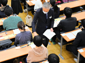 大学入学共通テストで問題訂正文を配る職員=2025年1月18日午前、東京都文京区、上野創撮影