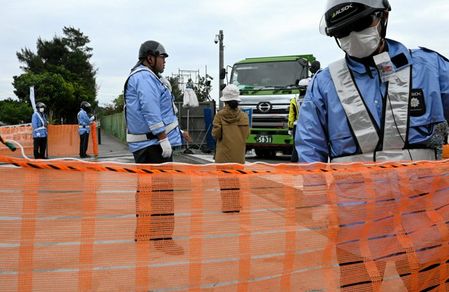 今年6月の事故を受け、ネットフェンスが張られた安和桟橋の出口。抗議活動をする女性が、2分ほどかけてダンプの前方をゆっくり横断した=2024年12月24日午後2時6分、沖縄県名護市、小野太郎撮影