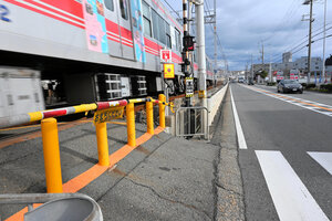 山陽電車に接触し、2人が死亡した踏切。遮断機の外側に立って信号機が青になるのを待つスペースは狭く、近くを車が通り過ぎる=2025年1月10日午後2時1分、神戸市垂水区、原野百々恵撮影