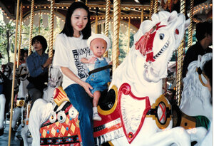 遊園地で蓉子さんとメリーゴーラウンドに乗る2歳ごろの里紗さん=結星蓉子さん提供