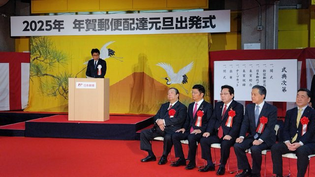 年賀配達の式典であいさつする日本郵政の増田寛也社長（左）。前列左は村上誠一郎総務相=1月1日午前8時9分、東京都新宿区の新宿郵便局