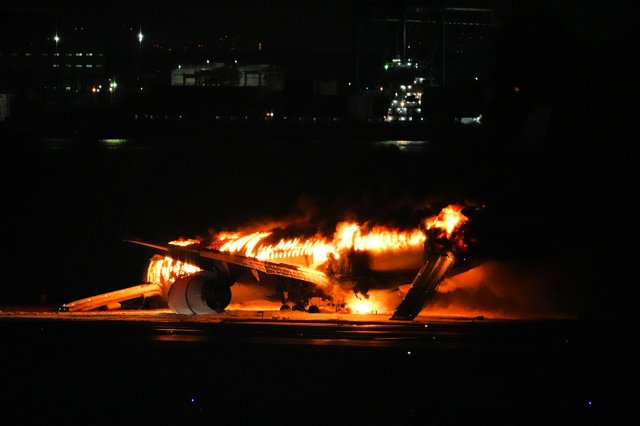 炎をあげて燃える航空機=2024年1月2日午後6時35分、羽田空港、小玉重隆撮影  