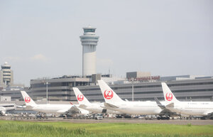 羽田空港に駐機する日航機。中央後方は管制塔=2024年8月5日午前10時43分、羽田空港、朝日新聞社機から、上田幸一撮影