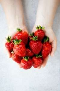 Strawberries held in hands cupped together 