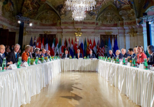 Group of world leaders sitting around table set up.