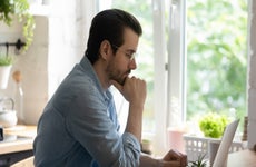 A man sits thinking at a desk