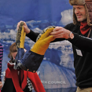 A man and a group of children testing out cold weather clothing