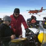 Scientists examining information in the snow.