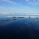 A group of clouds in the sky over a body of water.