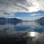 A body of water with a mountain in the background.