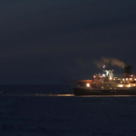 A large body of water with a reseach station in the night sky.