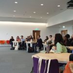 A group of students listening to a talk in a conference room