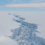 A plane flying over a snow covered slope