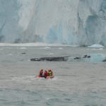 A group of people riding skis on a body of water