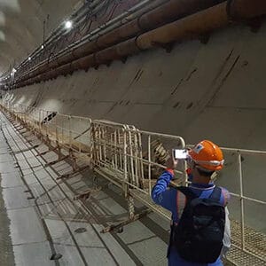 Engineer in a tunnel holding a electronic device