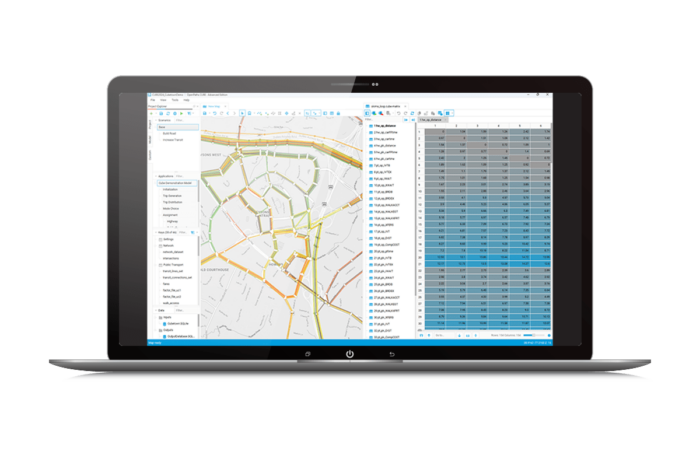 A laptop screen displaying a geographic information system (GIS) software interface, showing a detailed map on the left and a data table on the right.