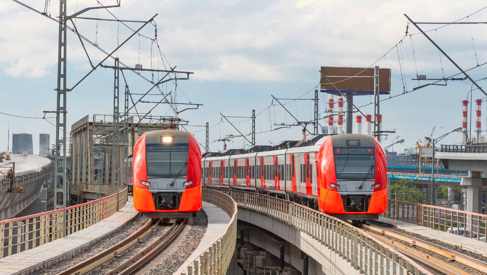 czerwone pociągi metra zbliżające się do widza, jadące po torach kolejowych