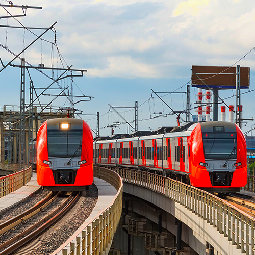 czerwone pociągi metra zbliżające się do widza, jadące po torach kolejowych