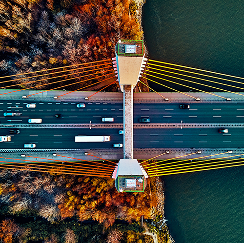 uma vista aérea de uma ponte sobre um rio com uma borda verde sobreposta