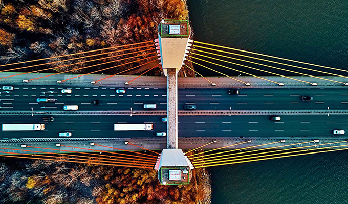 aerial view of bridge spanning river and forest during the fall