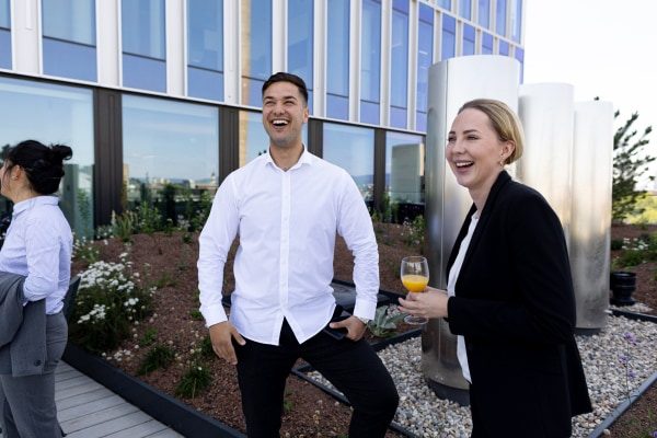 Mehrere Mitarbeitende treffen sich auf der Terrasse