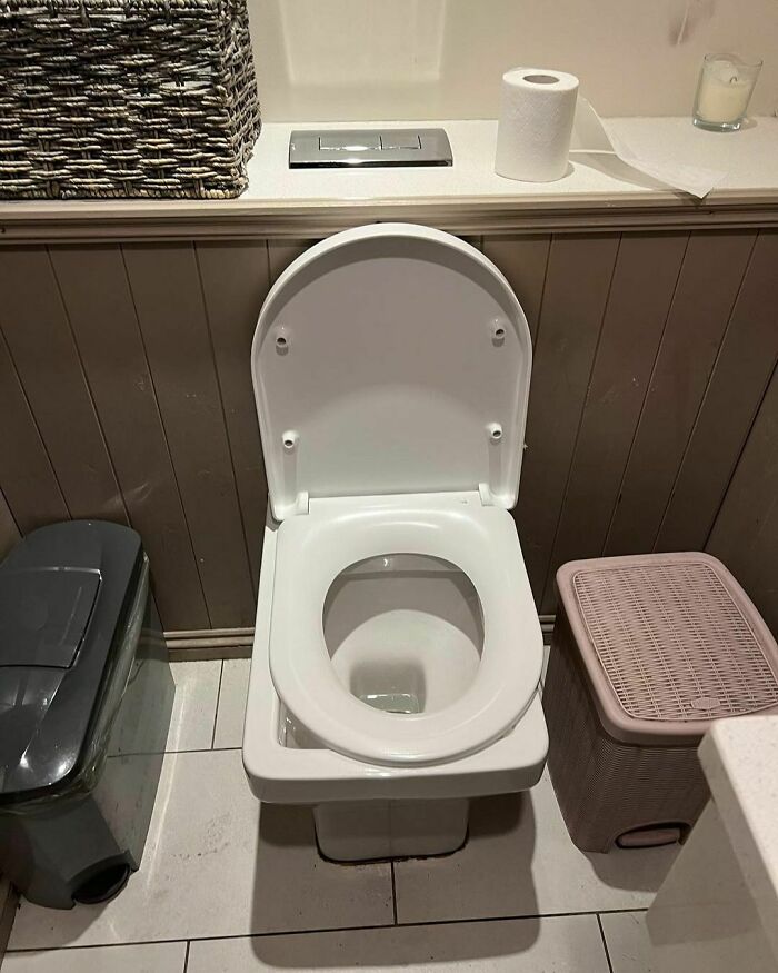 A design disaster with a misaligned toilet and shelf, making the toilet hard to access.