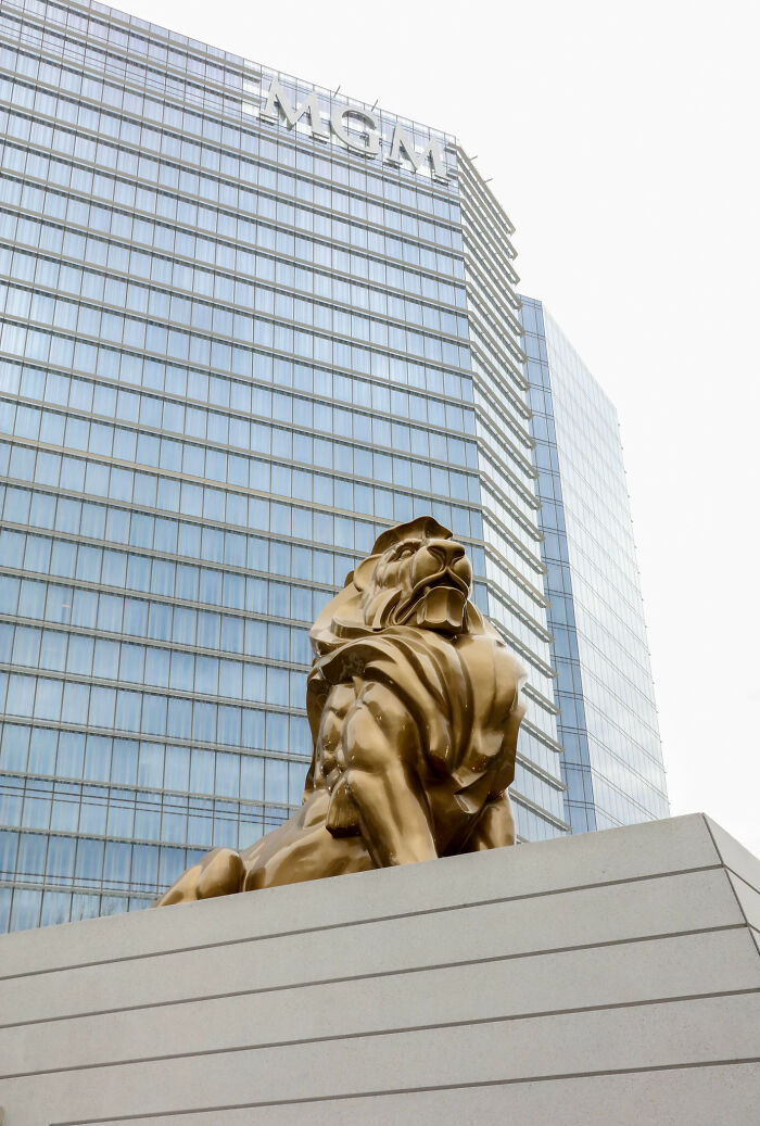 Golden lion statue at MGM building with reflective glass windows.