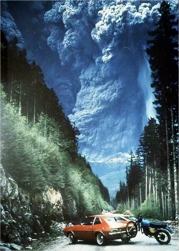 A massive volcanic eruption dwarfs a car and motorcycle in a forest, illustrating megaphobia triggers.