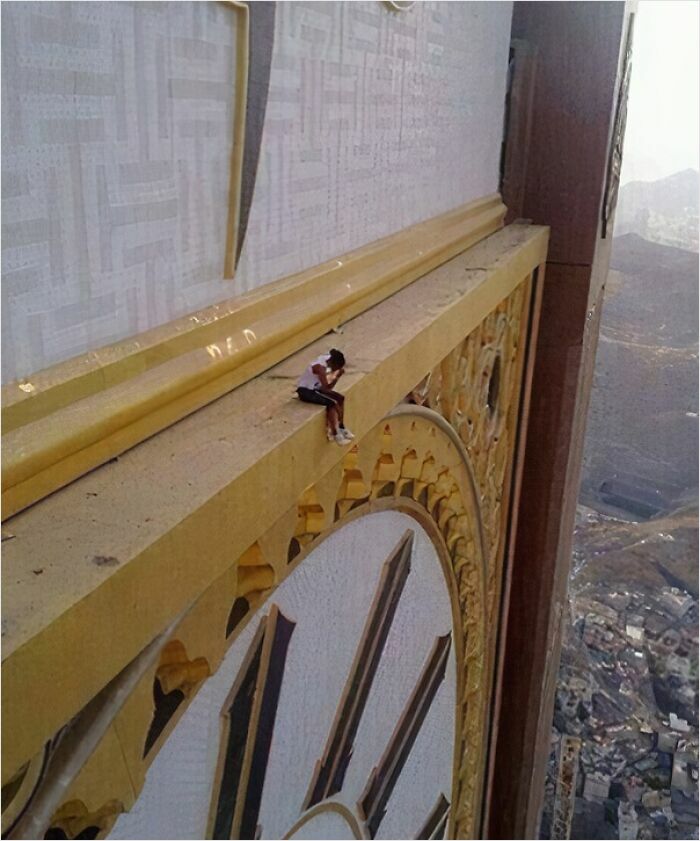 Person sitting on ledge of a gigantic clock tower, illustrating fear of gigantic things for those with megalophobia.