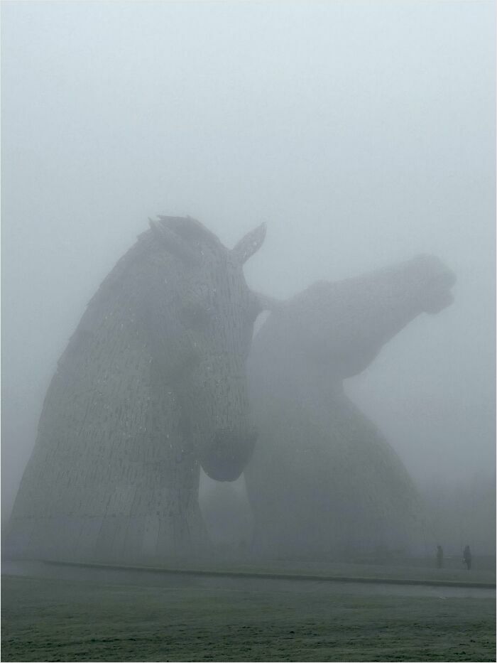 Foggy view of gigantic horse head sculptures, a striking sight for those with megalophobia.