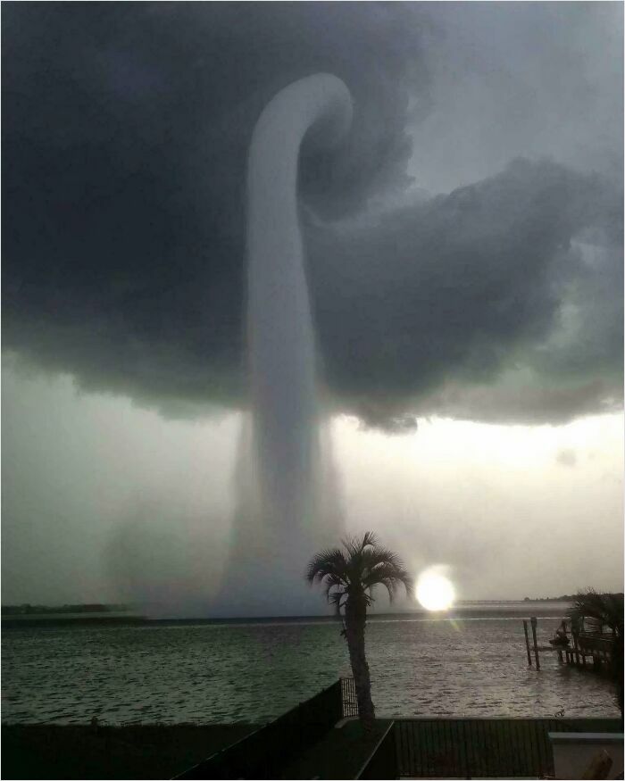 Massive waterspout over the ocean under ominous dark clouds, showcasing a phenomenon that triggers megalophobia.