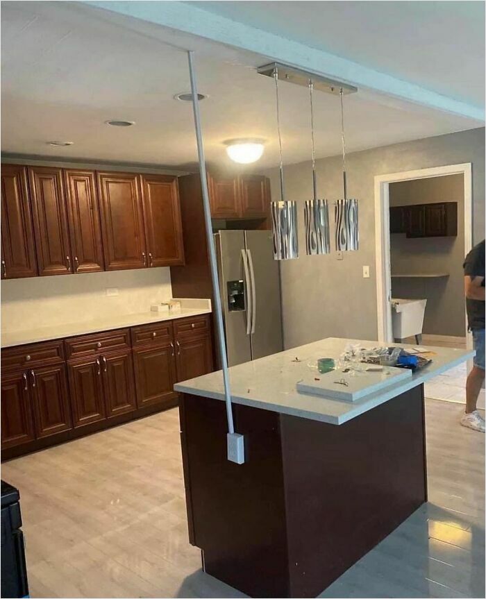 Kitchen design disaster featuring a pole awkwardly placed through the countertop, highlighting a design mishap.