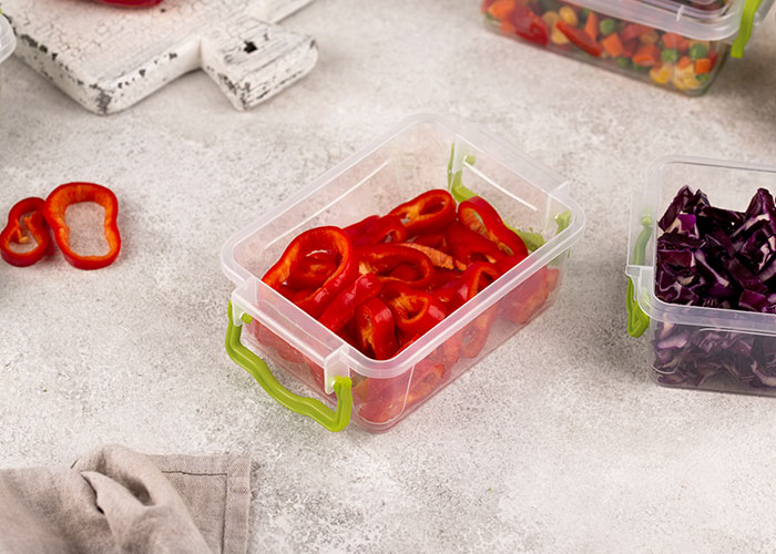 Plastic containers filled with sliced red peppers, showcasing frugal hacks for food storage to save money.