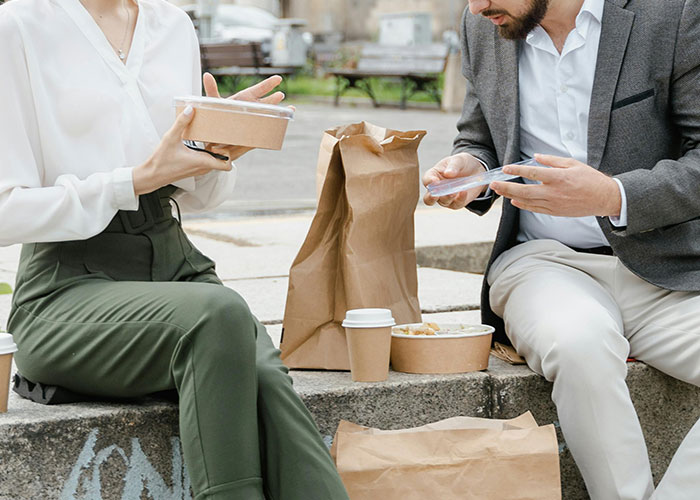 Two people enjoying a budget-friendly meal outdoors, highlighting creative frugal hacks to save cash.