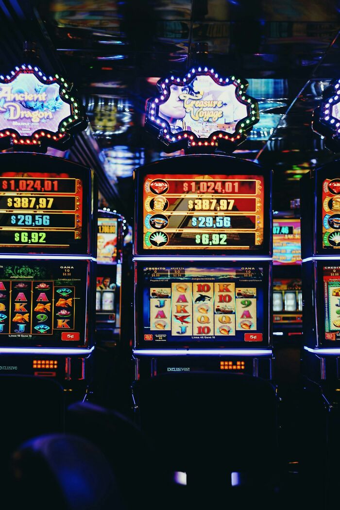 Slot machines in a dimly lit casino, showcasing bright displays and flashing lights.