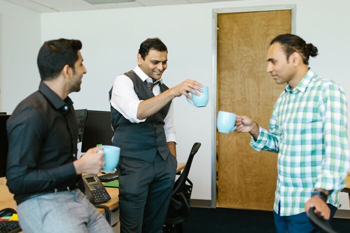 Casino employees having a casual coffee break, chatting and laughing behind the scenes at work.