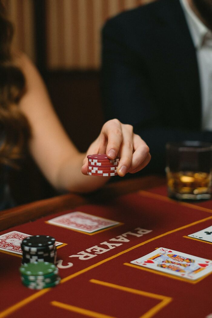 Casino employee holding poker chips at a blackjack table, offering a glimpse behind the scenes.