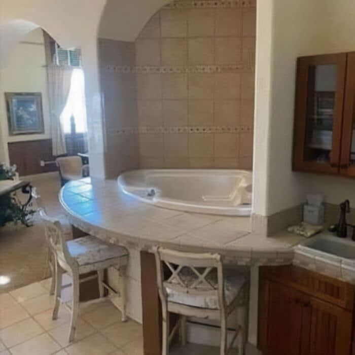 Bathtub design disaster with tiles extending into a seating area, raising questions about practicality.