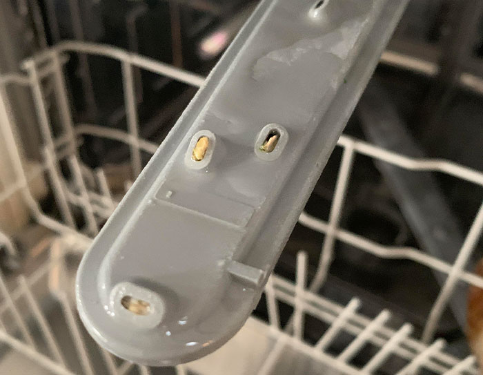 Close-up of a dishwasher arm incorrectly installed, showcasing using things wrong way.