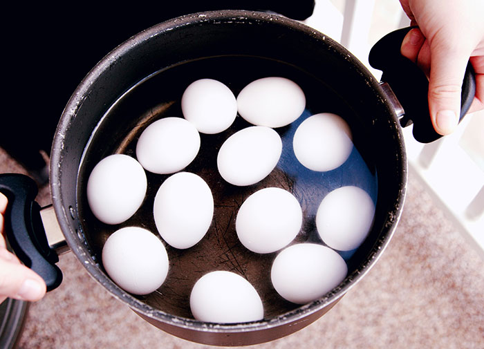 Boiling eggs in a pot, possibly using them the wrong way.