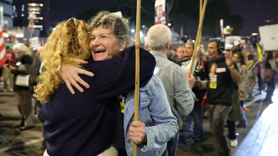 Menschen in Tel Aviv jubeln.