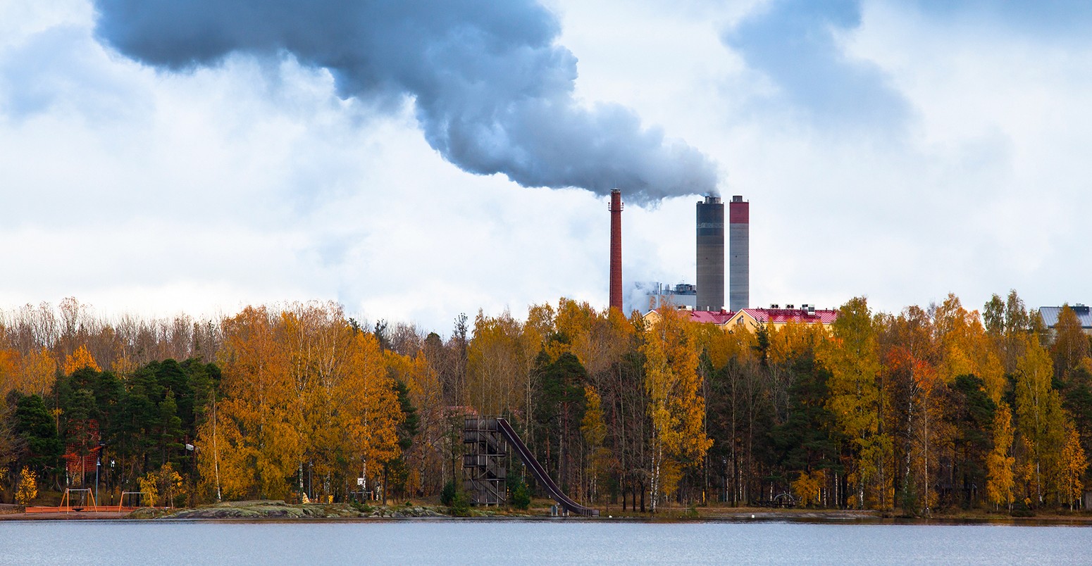 Air pollution from smoke coming from three factory chimneys