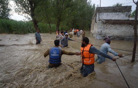 Citizens make their way through flooded streets with difficulty in the Dagai Mukaram Khan region, Pakistan.