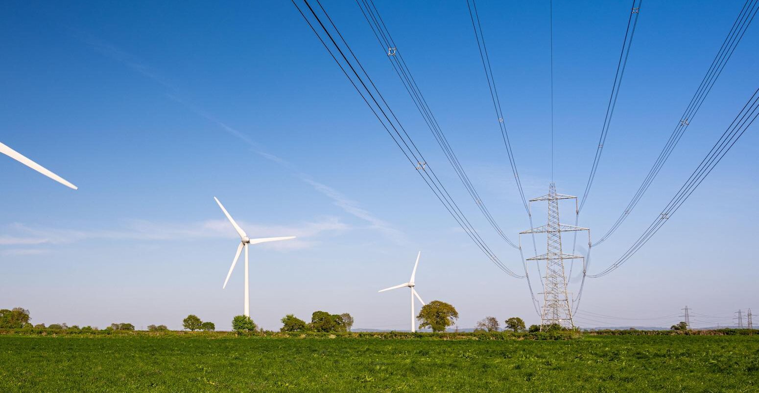 Wind turbines beside national grid high voltage power lines in Gloucestershire.