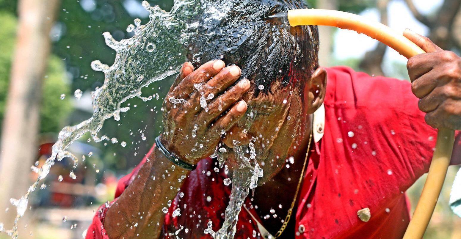 A person washes his face with water during high temperature weather day in Dhaka, Bangladesh, on April 11, 2023.