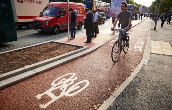 Cycling using cycle lanes on Oxford Road, Manchester.